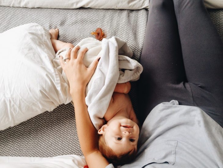 chica con bebé en cama