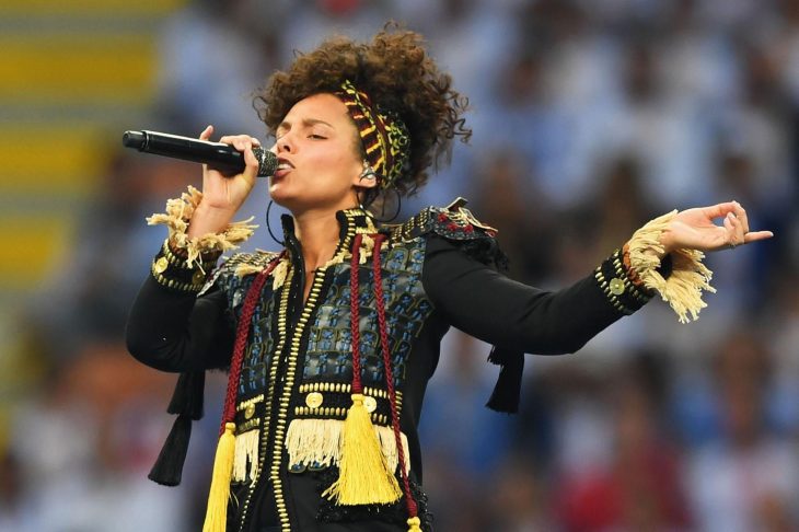 Mujer de cabello rizado con micrófono en estadio 