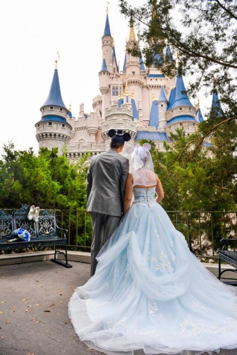 Pareja de novios dando la espalda viendo el castillo de Disney