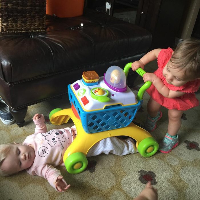 niñas pequeñas jugando con carrito