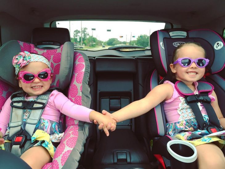 niñas con lentes tomadas de la mano sonriendo