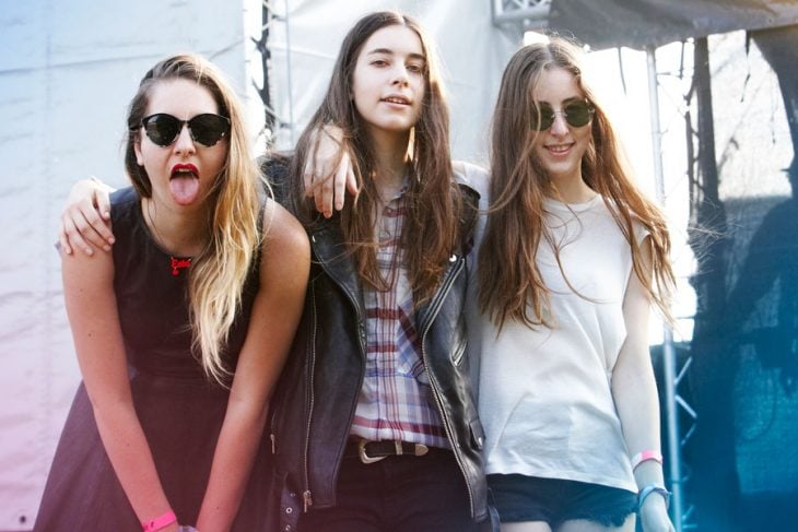 tres mujeres jovenes con cabello largo una saca la lengua 