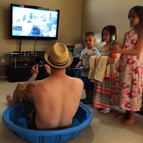 padre jugando en tina con hijos a un lado