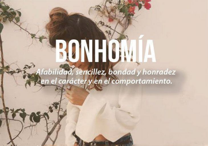 mujer mirando hacia abajo con chongo y blusa blanca con frase 