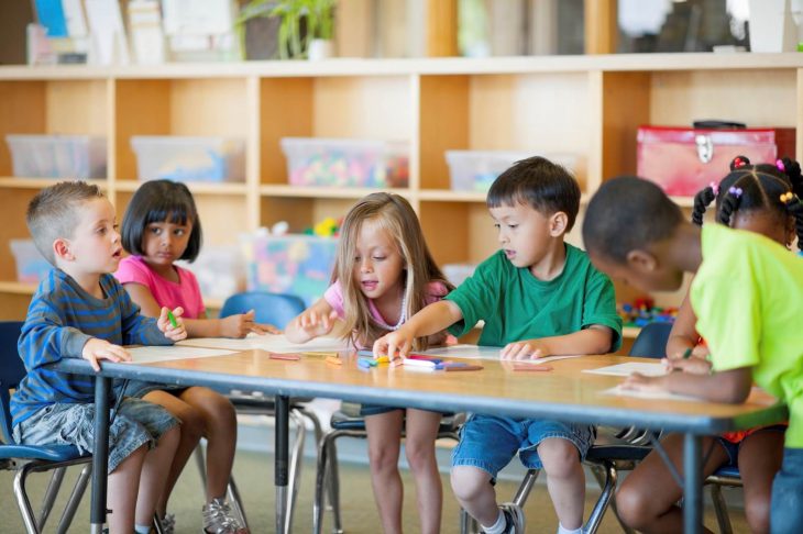 niños sentados en salón de clases 