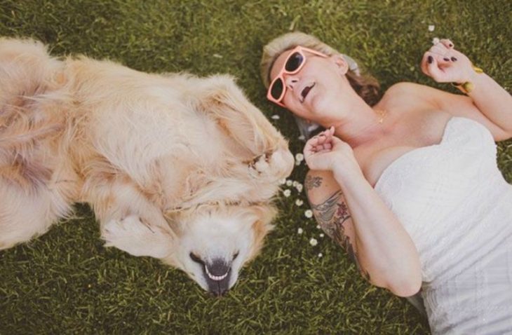 perro en el cesped y mujer rubia con vestido blanco y lentes de sol 