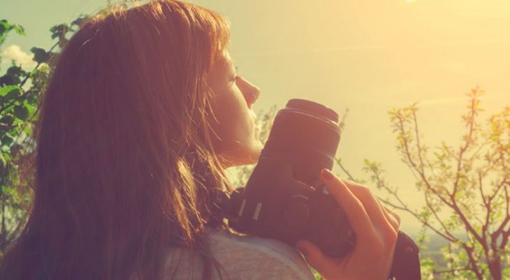 mujer con cámara fotográfica y arboles 