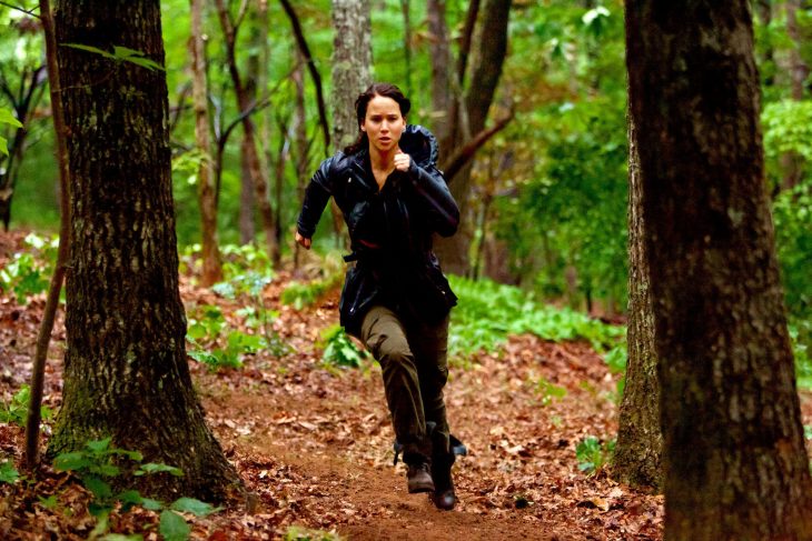 mujer blanca y cabello negro corriendo en el bosque 