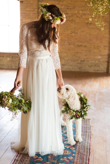 novia con vestido blanco y su perro con collar de flores 