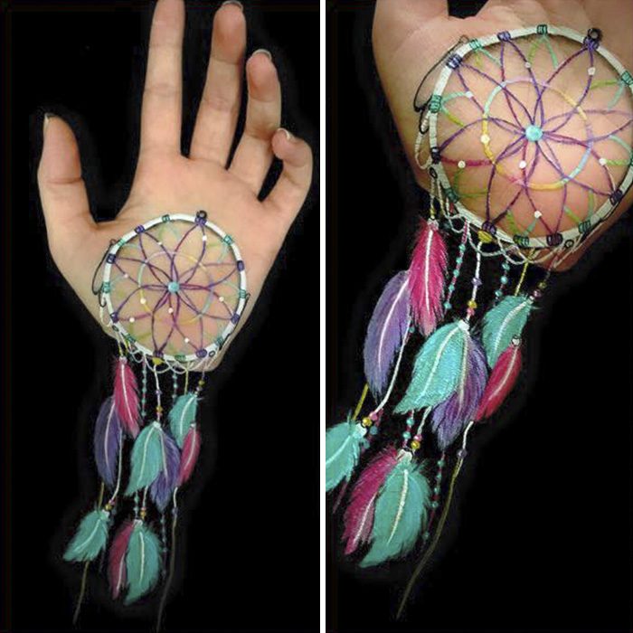 Chica que crea ilusiones ópticas en su mano, con un atrapa sueños dibujado en su brazo 