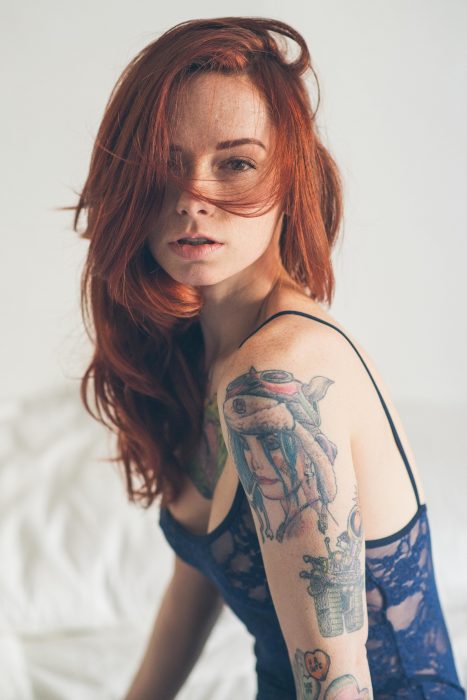 Chica peliroja con tatuajes en el brazo 