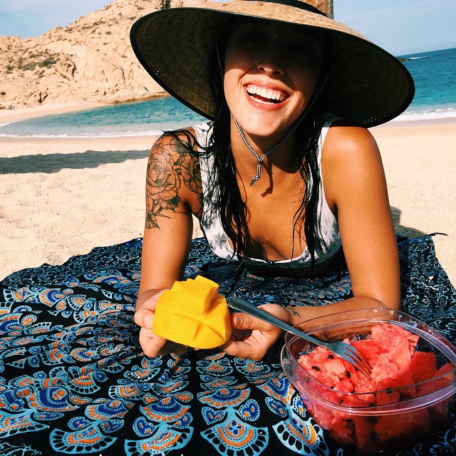 Chica con el hombro tatuado en la playa 