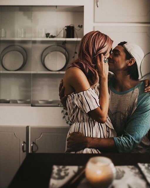 Pareja besándose en la cocina de una casa 