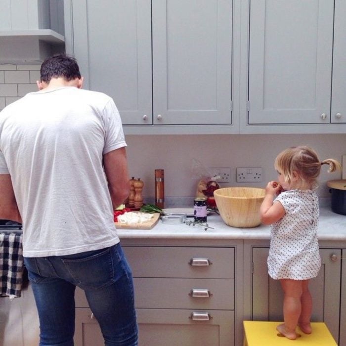 Niña cocinando junto a su papá en la cocina 