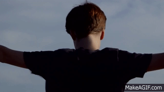 gif niño de espaldas con los brazos abiertos en el aire 