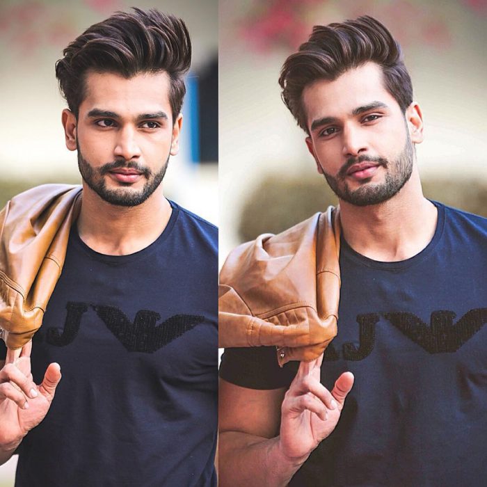 Rohit Khandelwal nuevo Mr. World sujetando una chaqueta al hombro y posando para una sesión de fotos 