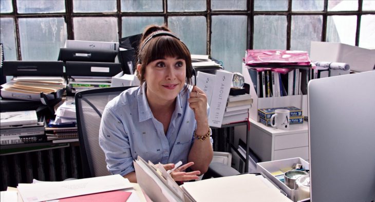 mujer de cabello negro contestando telefono en trabajo 