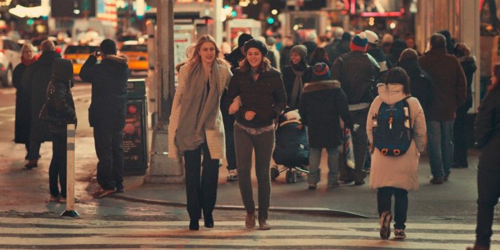 dos mujeres sonriendo cruzando la calle 