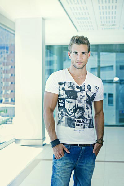 Ginecólogo Manuel Rico posando para una sesión de fotos en camisa blanca y pantalón de mezclilla