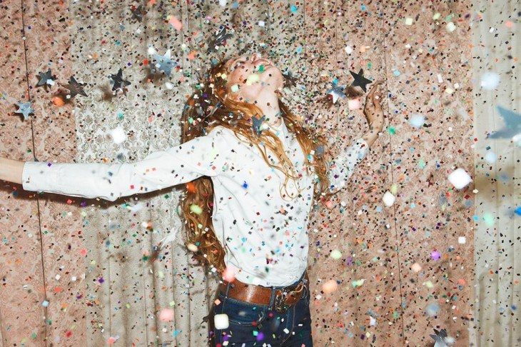 Chica feliz en un cuarto con estrellas de papel 