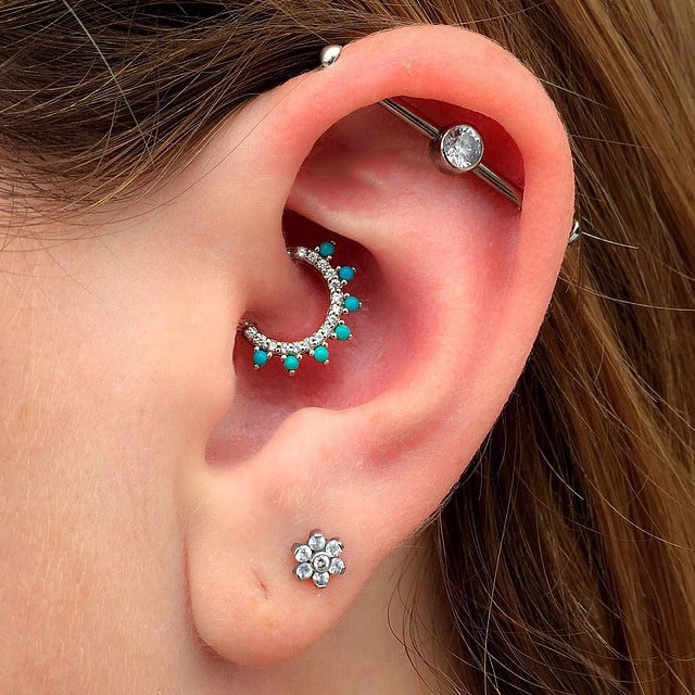 Chica con un piercing en la oreja en color turquesa 