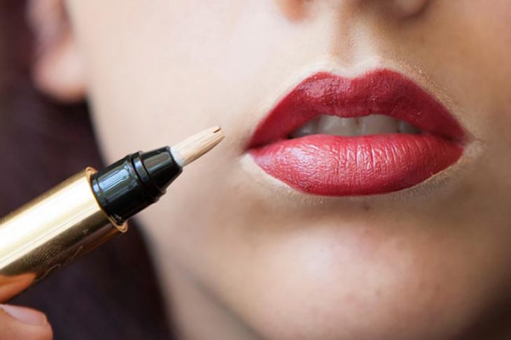 mujer de labios rojos y corrector 