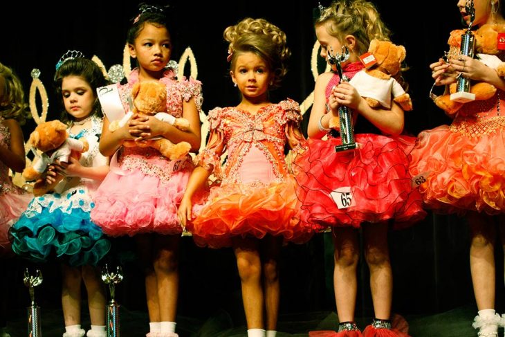 gurpo de niñas con cabello rubio, tiaras y vestidos