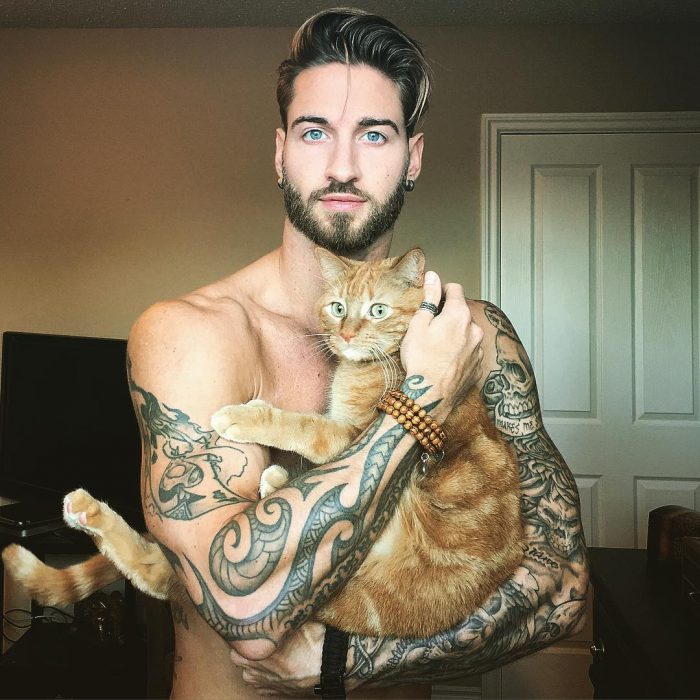 Travis DesLaurier abrazando a su gato 