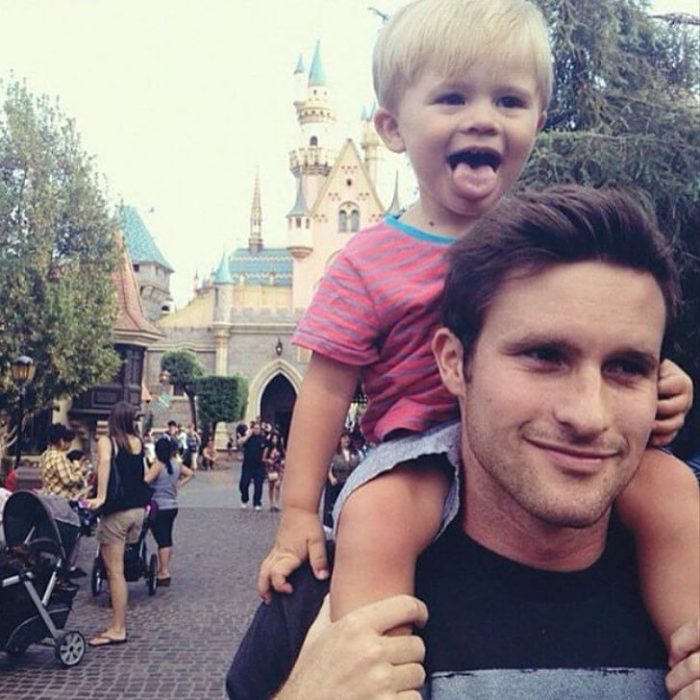 papá guapo DILF con bebé en Disneyland