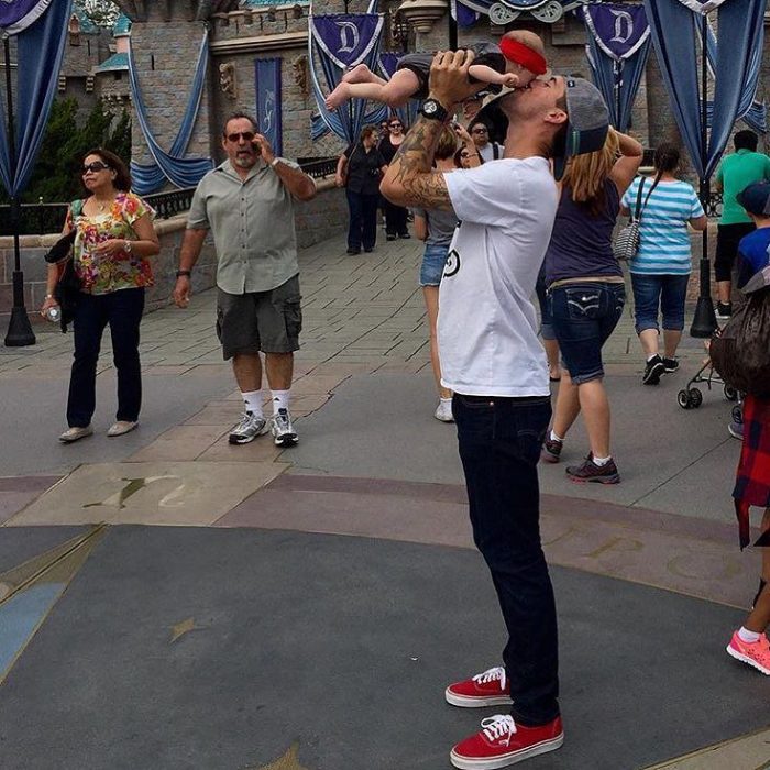 papá guapo DILF con bebé en Disneyland