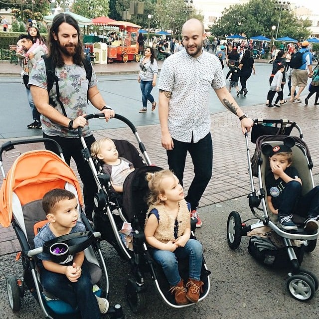 papás guapos DILFs con bebé en Disneyland