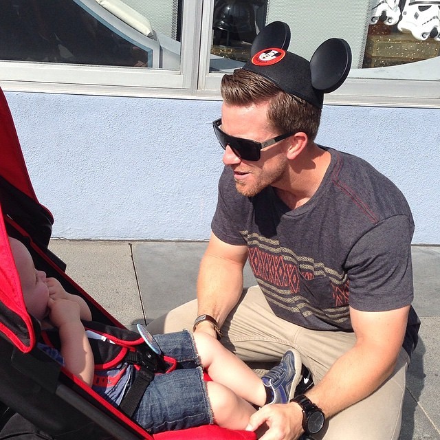 papá guapo DILF con bebé en Disneyland