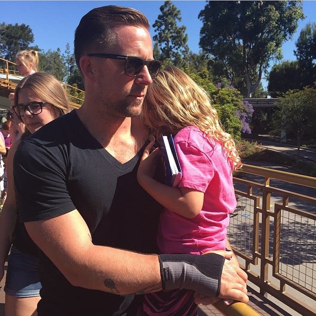 papá guapo DILF con bebé en Disneyland