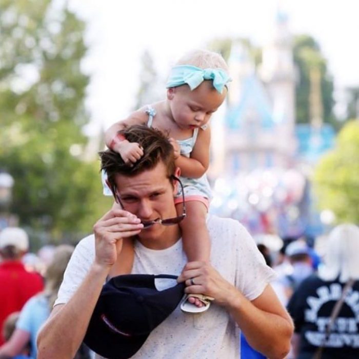 papá guapo DILF con bebé en Disneyland