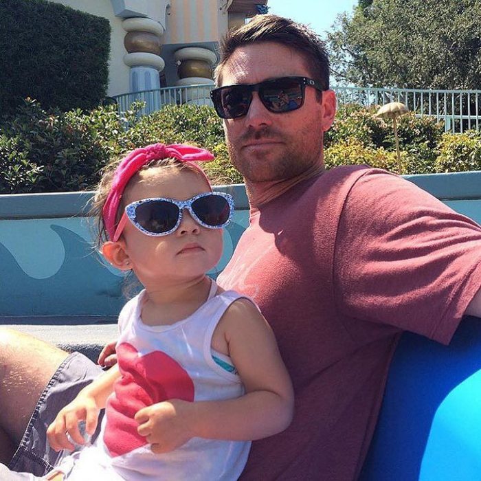 papá guapo DILF con bebé en Disneyland