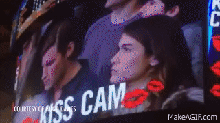 hombre en celular y mujer emocionada en camara de beso gif 