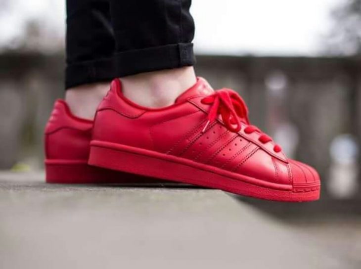 pies de mujer con tenis adidas superstar rojo