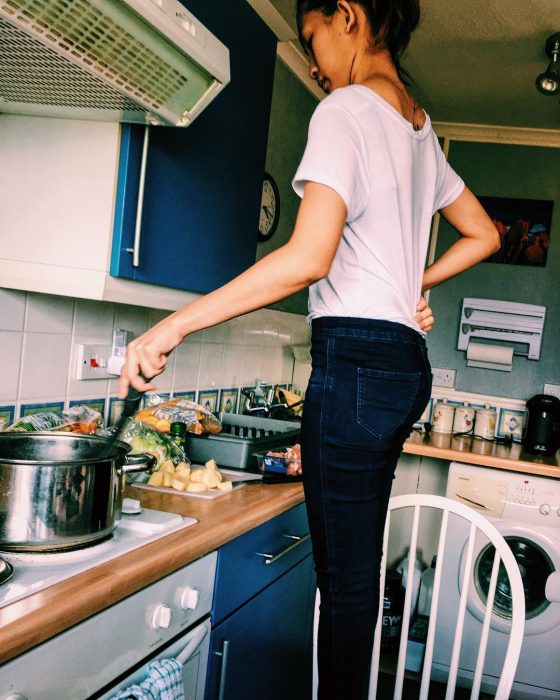 chica bajita sobre una silla cocinando