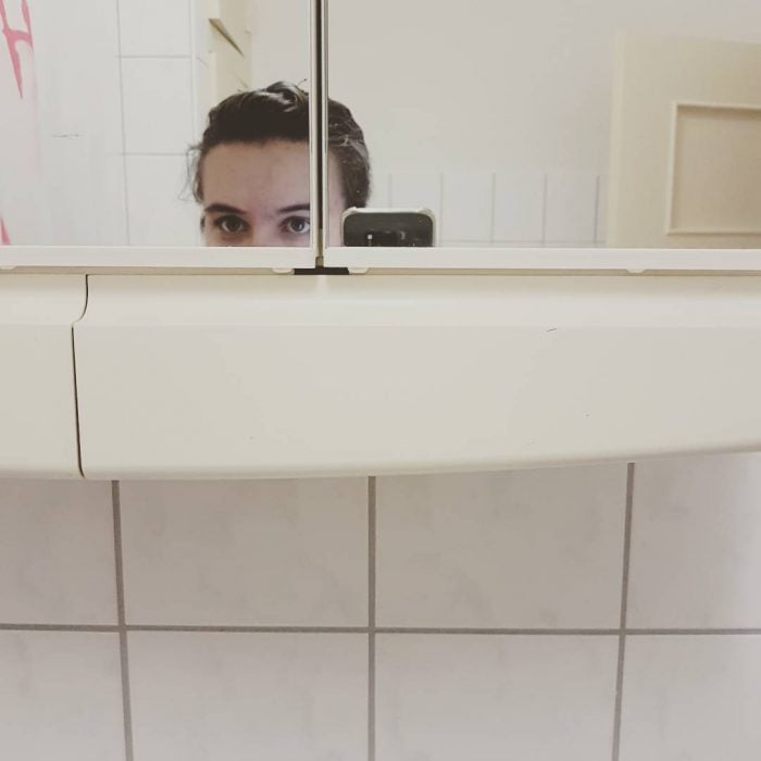 chica bajita tomando selfie en el baño