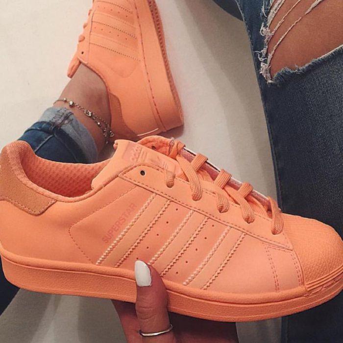 pies de mujer con tenis adidas superstar naranja