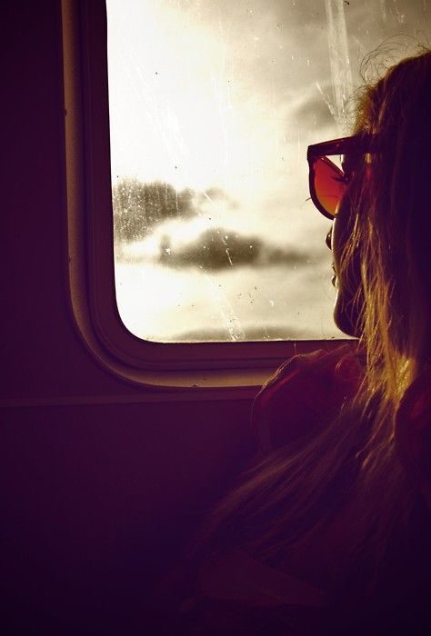 Mujer mirando por la ventanilla de un avión.