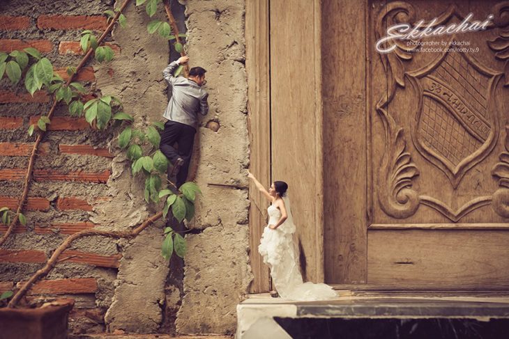 pareja en escenario miniatura hombre subiendo pared y mujer con vestido de novia 