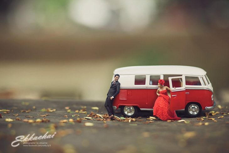 pareja en escenario miniatura saliendo de coche rojo 