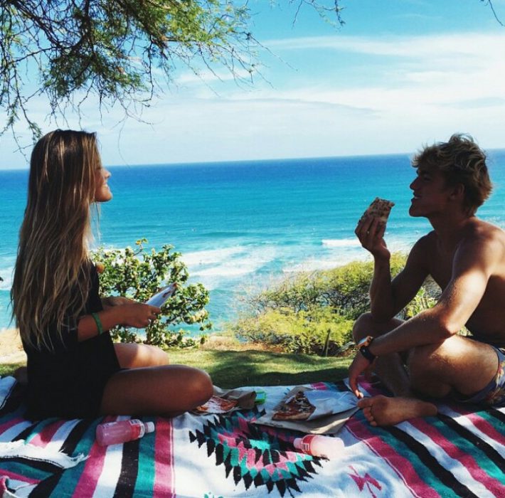 Pareja comiendo en la playa. 