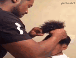 hombre peinando a niña con cabello afro 