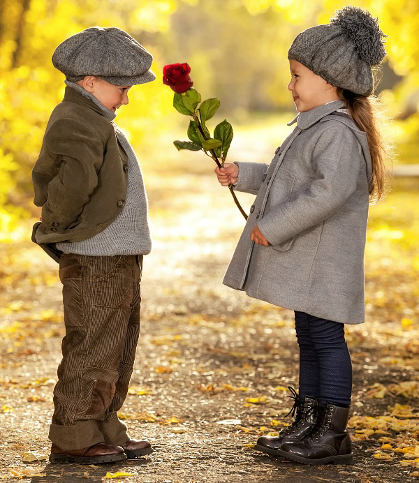 Niña dándole una flor a un niño. 