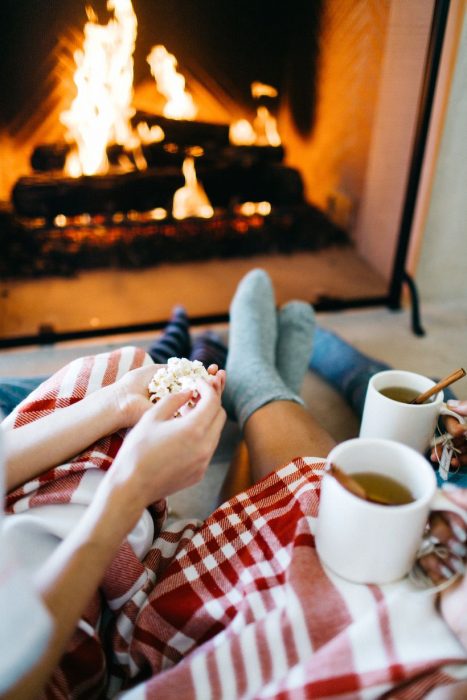 Pareja comiendo palomitas y tomando té. 