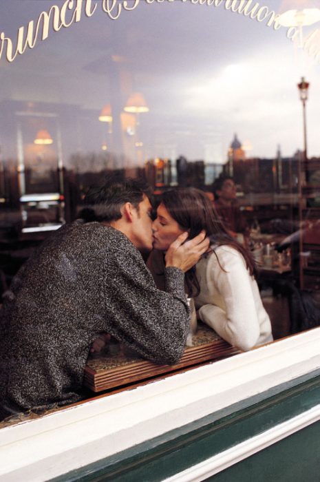 Pareja besándose en un café. 