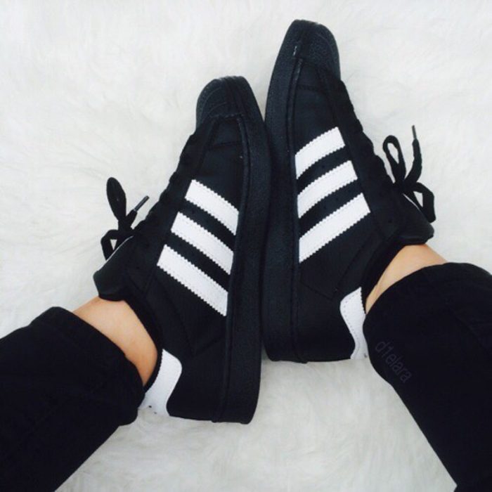 pies de mujer con tenis adidas superstar negro 