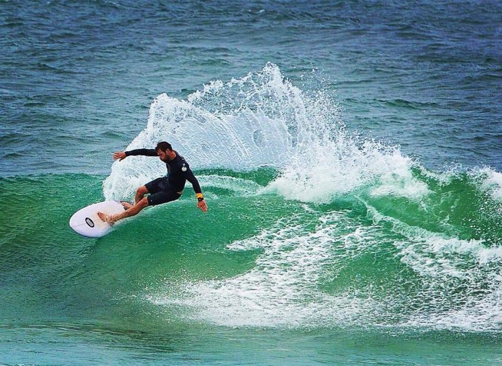 hombre en tabla de surf y olas en el mar 